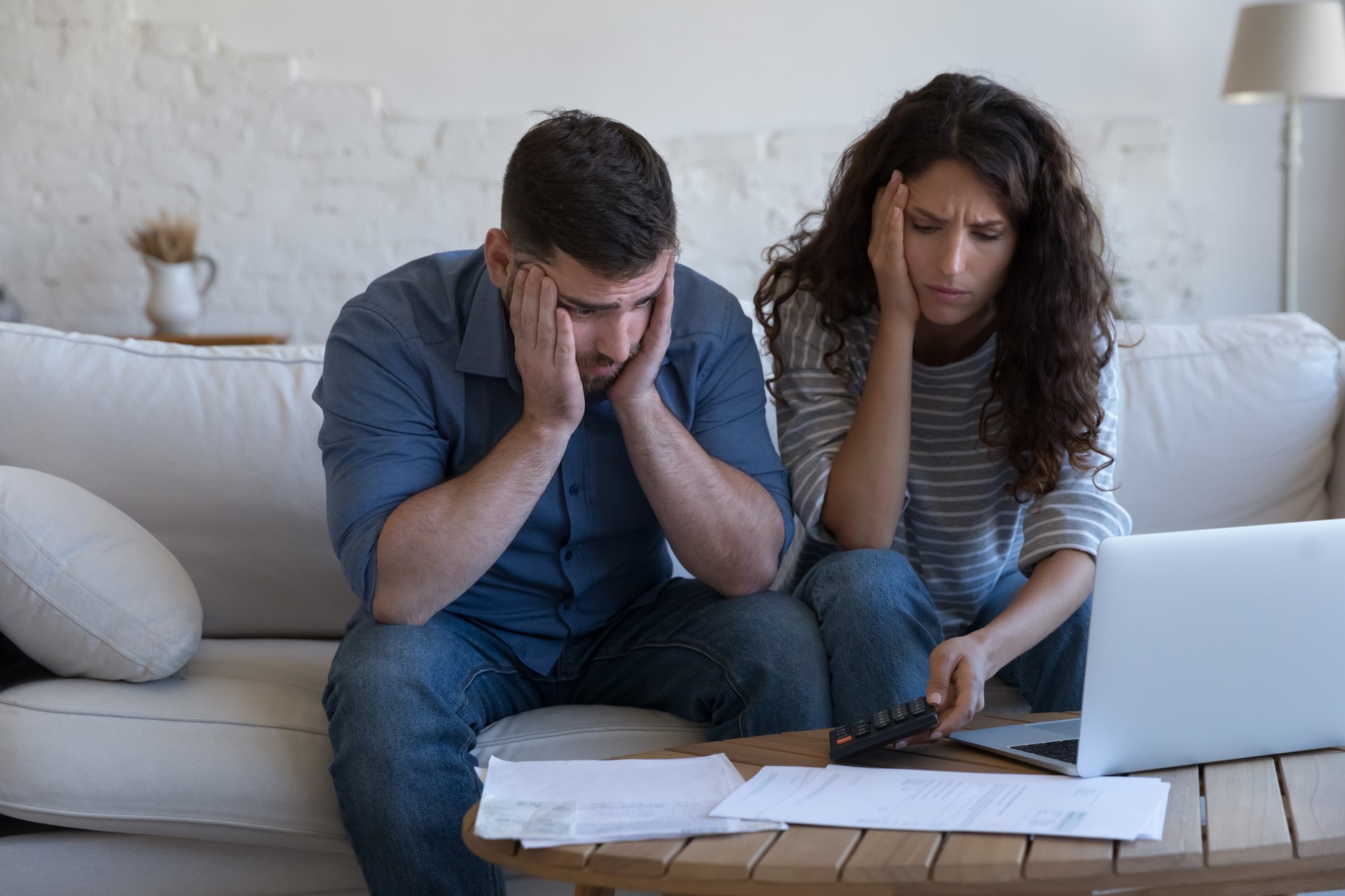 Concerned upset millennial couple counting overspent budget